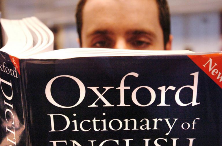 мужчина читает книгу оксфордский словарь новое издание